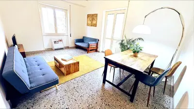 a living room with a table and a blue couch at Domus Remo Room #2 in Rome