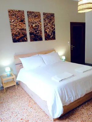 a bedroom with a large white bed with three paintings on the wall at Domus Remo Room #2 in Rome