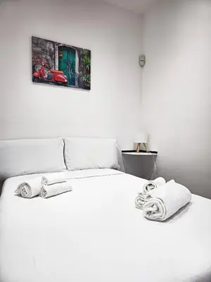 a bedroom with a white bed with towels on it at Nōma Pigneto by Hostand in Rome