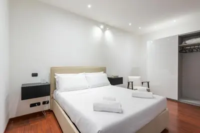 a bedroom with a white bed with two towels on it at Nōma Pigneto by Hostand in Rome