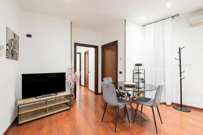 a dining room with a table and a television at Nōma Pigneto by Hostand in Rome