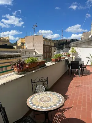 a kitchen with a white refrigerator and a clock on the wall at Casa del Grillo in Rome