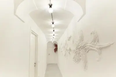a hallway with white walls and a painting on the wall at RipettArt Apt in Rome