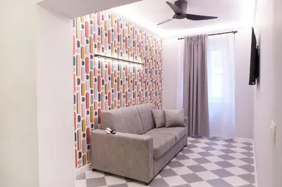 a living room with a chair and a ceiling fan at RipettArt Apt in Rome