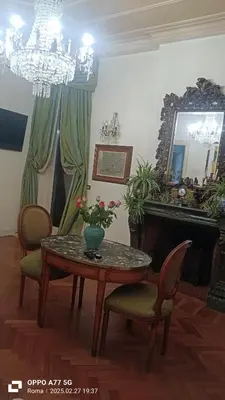 a dining room with a table and chairs and a mirror at Terrace of the Aureli in Rome