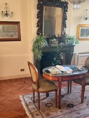 a living room with a table and a mirror at Terrace of the Aureli in Rome