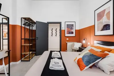 a bedroom with orange walls and a white bed at BDC - Stairway to Heaven in Rome