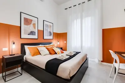 a bedroom with a large bed with orange walls at BDC - Stairway to Heaven in Rome