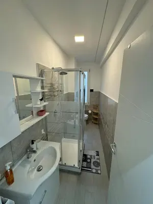 a bathroom with a glass shower and a sink at holiday home modern 2 rooms near colosseo in Rome