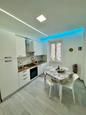a kitchen with a table and chairs in a room at holiday home modern 2 rooms near colosseo in Rome