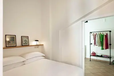 a white bedroom with a bed and a closet at TrastevereHome - Secret Balcony in the Heart of Rome Trastevere in Rome
