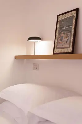a shelf above a bed with a picture on it at TrastevereHome - Secret Balcony in the Heart of Rome Trastevere in Rome