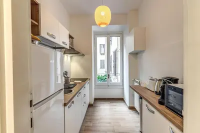 a kitchen with a white refrigerator and a window at Dimora Lunetta - Modern Flat in Vatican District in Rome