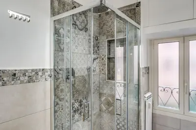 a bathroom with a shower with a glass door at Dimora Lunetta - Modern Flat in Vatican District in Rome