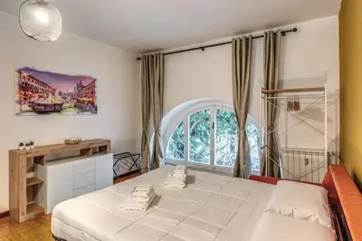 a bedroom with a white bed and a large window at Dimora Lunetta - Modern Flat in Vatican District in Rome