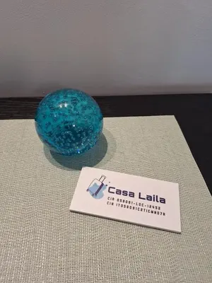 a blue glass ball sitting on a table with a sign at Casa Laila in Rome