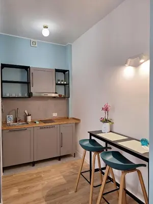 a kitchen with a table and two blue chairs at Casa Laila in Rome