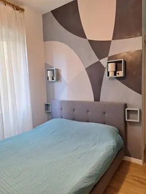 a bedroom with a bed with a painting on the wall at Casa Laila in Rome