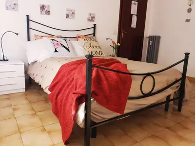 a bedroom with a bed with a red blanket on it at Holy Vatican Home in Rome