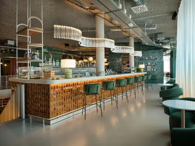 a bar in a restaurant with green chairs at The Social Hub Rome Extended Stay in Rome