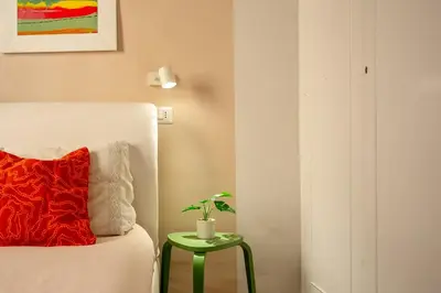 a room with a bed and a table with a plant on it at Trastevere 2 Badrooms Design Appartment in Rome