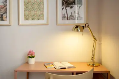 a desk with a lamp and two books on it at Trastevere 2 Badrooms Design Appartment in Rome
