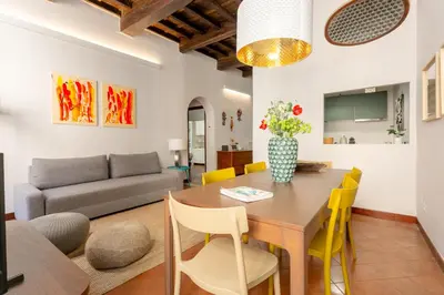 a living room with a wooden table and yellow chairs at Trastevere 2 Badrooms Design Appartment in Rome