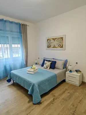 a bedroom with a bed with a blue comforter at B&B Gregorio VII in Rome