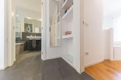 a kitchen with white walls and a wooden floor at Elegant house in Monteverde in Rome