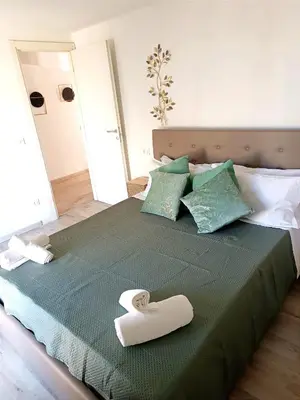 a bed with a green comforter with a towel on it at Jeb's Sweet Rooftop in Rome