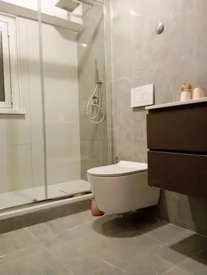 a bathroom with a toilet and a glass shower at Jeb's Sweet Rooftop in Rome