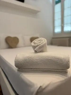 a stack of towels sitting on top of a bed at Suite Eroi in Rome