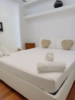 a white bed with two towels and hearts on it at Suite Eroi in Rome