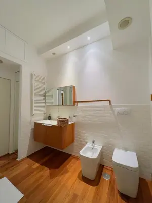 a white bathroom with a toilet and a sink at Suite Eroi in Rome