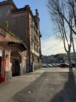 an empty street next to an old brick building at Suite Eroi in Rome