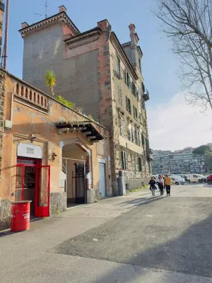 a group of people walking down a street next to a building at Suite Eroi in Rome