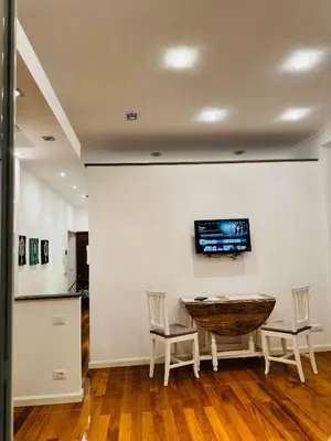 a room with a table and two chairs and a tv on the wall at Suite Eroi in Rome