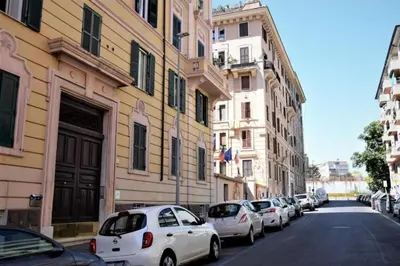 a row of cars parked on a street next to buildings at Apartment near the Vatican in Rome