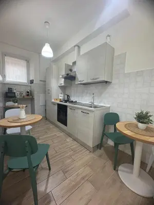 a kitchen with two tables and two chairs and a sink at Apartment near the Vatican in Rome
