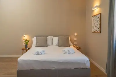 a bedroom with a white bed with two towels on it at Penthouse Vado Collection in Rome