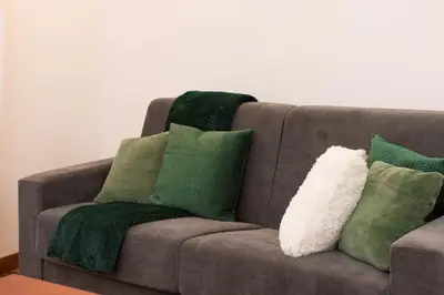 a couch with green and white pillows on it at Braliu Apartment in Rome
