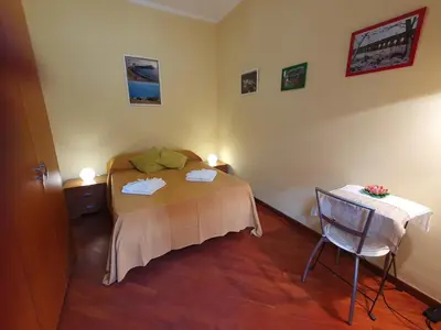 a bedroom with a bed and a chair in it at Domus Monteverde in Rome