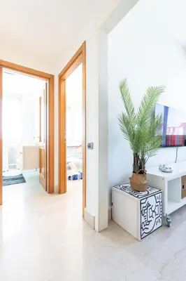a living room with a potted plant in a white room at Urban Haven Roma, Porta Maggiore in Rome