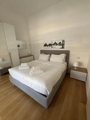 a bedroom with a large bed with white sheets at Domus Romana Prati in Rome