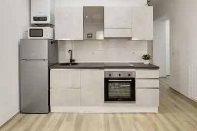 a kitchen with white cabinets and a refrigerator at central basic apartment in Rome
