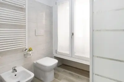 a white bathroom with a toilet and a sink at central basic apartment in Rome