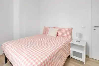 a bed with a checkered blanket and a night stand at central basic apartment in Rome