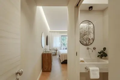 a bathroom with a tub and a bed and a mirror at The Romex in Rome