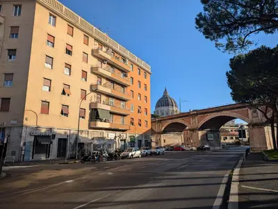 an empty city street with a building and a bridge at auntieshouseroma in Rome