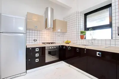 a kitchen with brown cabinets and a stainless steel refrigerator at Monteverde Nuovo Penthouse in Rome